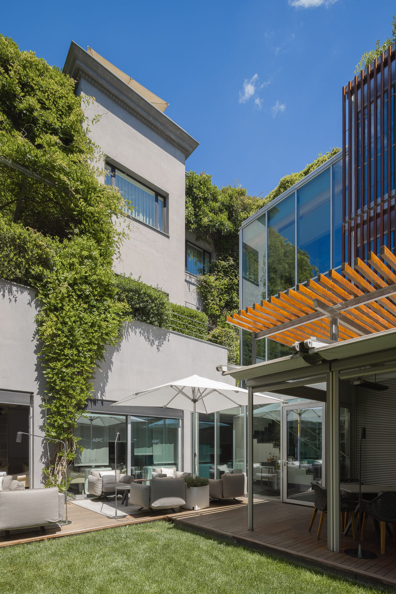 ÀBAC — La Fachada: Villa modernista cubierta de hiedra. El primer suspiro.